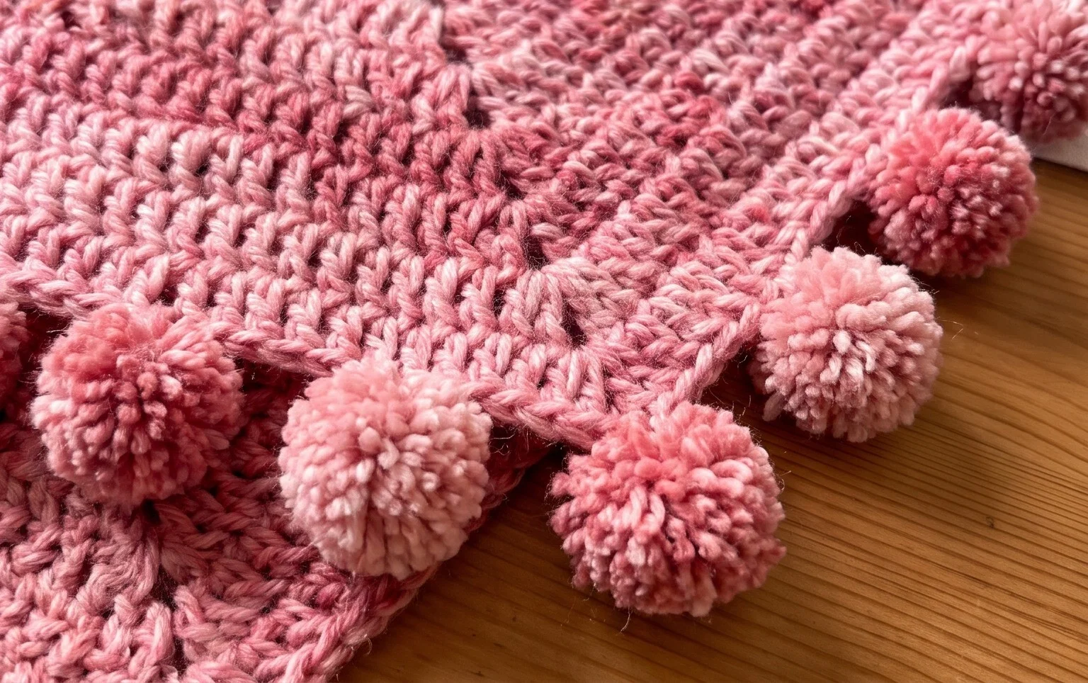 Poncho a crochet con borde de pompones